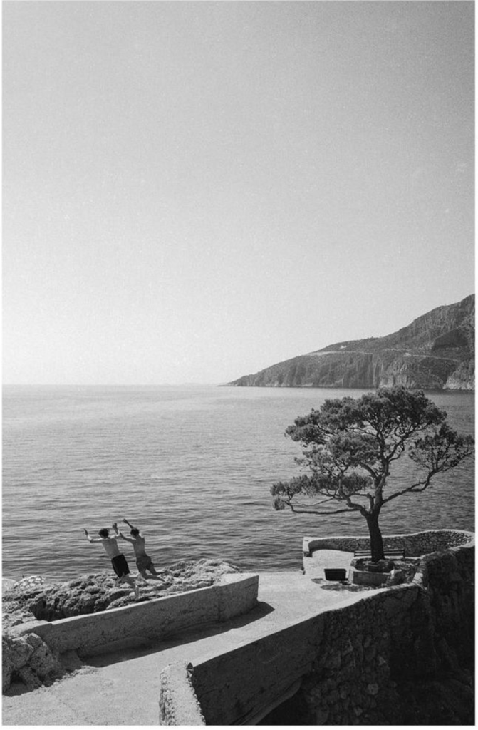 Blog poster and a friend in Greece holding hands and jumping into the ocean.